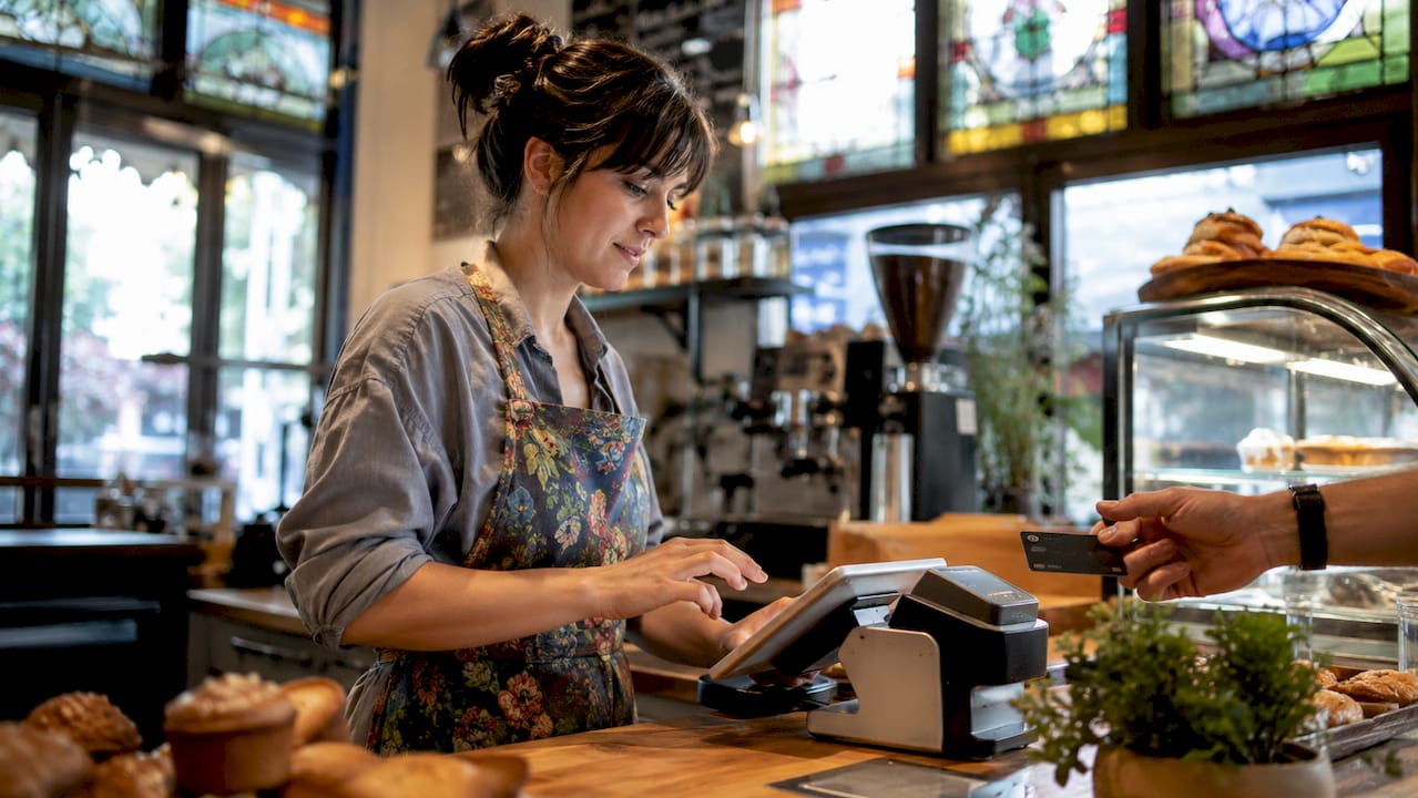 Barista processing café payment at counter