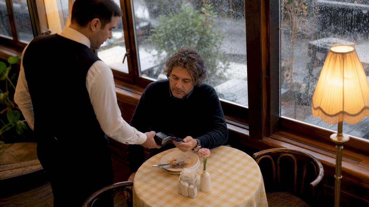 Waiter processing restaurant payment with terminal